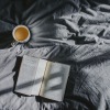 a coffee and a book on a bed